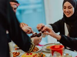 modern multiethnisch Muslim Familie Teilen ein Schüssel von Termine während genießen iftar Abendessen zusammen während ein Ramadan Fest beim Zuhause foto