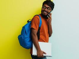 indisch Schüler mit Blau Rucksack, Brille und Notizbuch posieren auf grau und Grün Hintergrund. das Konzept von Bildung und Schulung. Zeit zu gehen zurück zu Schule foto