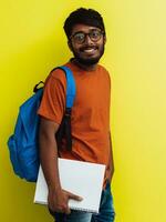 indisch Schüler mit Blau Rucksack, Brille und Notizbuch posieren auf Grün Hintergrund. das Konzept von Bildung und Schulung. Zeit zu gehen zurück zu Schule foto