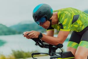 schließen oben Foto von ein aktiv Triathlet im Sportbekleidung und mit ein schützend Helm Reiten ein Fahrrad. selektiv Fokus