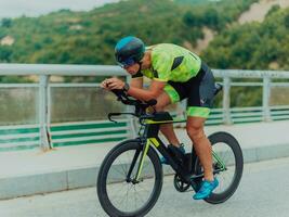 voll Länge Porträt von ein aktiv Triathlet im Sportbekleidung und mit ein schützend Helm Reiten ein Fahrrad. selektiv Fokus foto