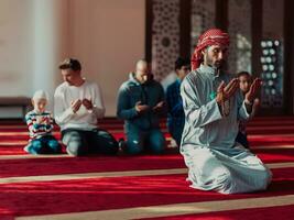 ein Gruppe von Muslime im ein modern Moschee beten das Muslim Gebet Namaz, während das heilig Monat von Ramadan foto