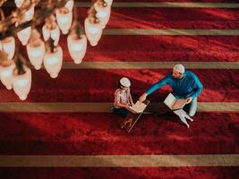 muslimischer gebetsvater und sohn in der moschee beten und lesen holly book quran zusammen islamisches bildungskonzept foto