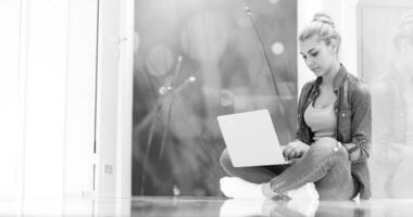 junge frauen, die laptop-computer auf dem boden verwenden foto