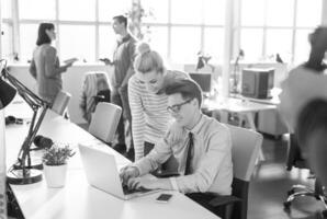 zwei geschäftsleute, die mit laptop im büro arbeiten foto