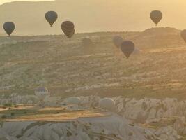 Antenne filmisch Drohne Aussicht von bunt heiß Luft Ballon fliegend Über Kappadokien foto