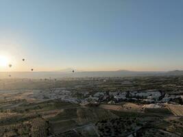 Antenne filmisch Drohne Aussicht von bunt heiß Luft Ballon fliegend Über Kappadokien foto