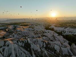 Antenne filmisch Drohne Aussicht von bunt heiß Luft Ballon fliegend Über Kappadokien foto