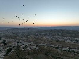 Antenne filmisch Drohne Aussicht von bunt heiß Luft Ballon fliegend Über Kappadokien foto