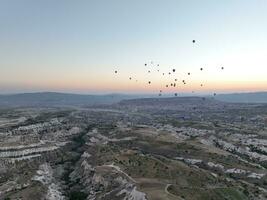 Antenne filmisch Drohne Aussicht von bunt heiß Luft Ballon fliegend Über Kappadokien foto