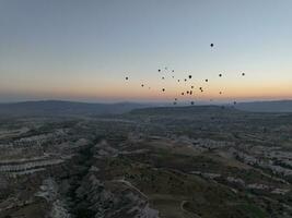 Antenne filmisch Drohne Aussicht von bunt heiß Luft Ballon fliegend Über Kappadokien foto