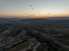 Antenne filmisch Drohne Aussicht von bunt heiß Luft Ballon fliegend Über Kappadokien foto
