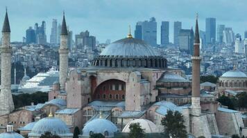 Festlegung umkreisen Antenne Drohne Schuss von ein Hagia Sophia heilig großartig Moschee mit Bosporus Brücke und Stadt Horizont mit ein Flagge auf das Hintergrund im Fatih, Istanbul, Truthahn beim Sonnenuntergang. foto