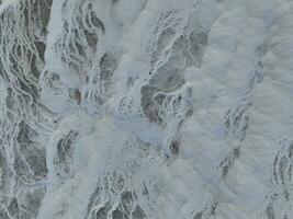 Pamukkale Travertine filmisch Antenne Drohne Filmaufnahme. Türkisch berühmt Weiß Thermal- Bad mit gesund sauber Wasser im ein schön Sonnenuntergang. foto