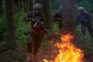 Soldat in Aktion bei Nacht beim Springen über Feuer foto