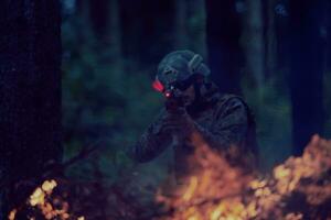 soldat in aktion, der auf waffenlaservisieroptik abzielt foto