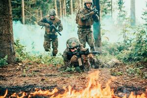 modern Krieg Soldaten umgeben durch Feuer Kampf im dicht und gefährlich Wald Bereiche foto