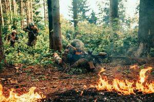 modern Krieg Soldaten umgeben durch Feuer Kampf im dicht und gefährlich Wald Bereiche foto