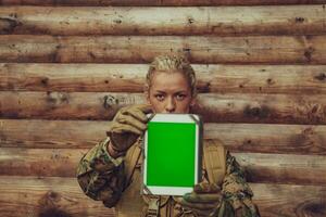 Frau Soldat mit Tablette Computer gegen alt hölzern Mauer im Lager foto