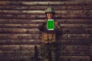 Frau Soldat mit Tablette Computer gegen alt hölzern Mauer im Lager foto