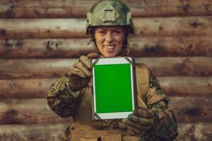 Frau Soldat mit Tablette Computer gegen alt hölzern Mauer im Lager foto