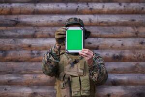 Soldat mit Tablet-Computer im Militärlager foto