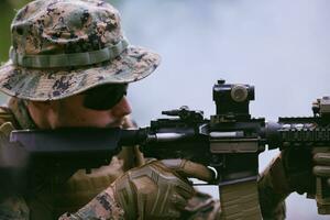 soldat in aktion, der auf waffenlaservisieroptik abzielt foto