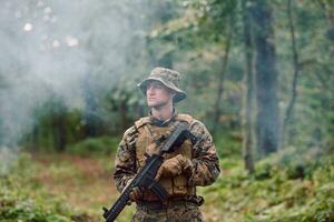 soldat in aktion, der auf waffenlaservisieroptik abzielt foto