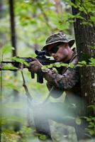 soldat in aktion, der auf waffenlaservisieroptik abzielt foto