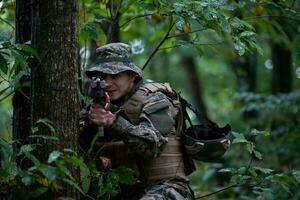 soldat in aktion, der auf waffenlaservisieroptik abzielt foto