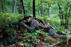 soldat in aktion, der auf waffenlaservisieroptik abzielt foto