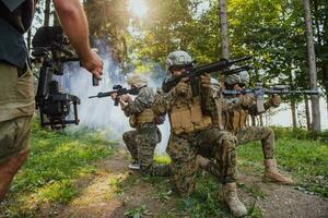 Videograf mit Fachmann Film Video Kamera kardanisch stabilisierend Ausrüstung nehmen Aktion schießen von Soldaten im Aktion im Wald foto