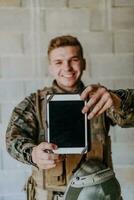 Soldat mit Tablette Computer gegen alt Backstein Mauer foto