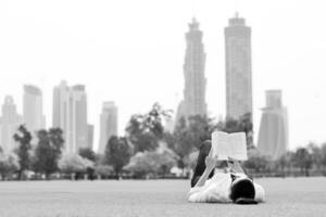 junge Frau, die ein Buch im Park liest foto