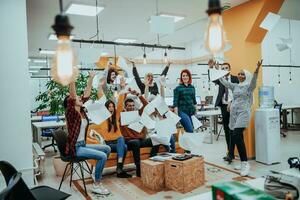 Gruppe von Geschäft Menschen werfen Papier im Luft beim modern Anfang Büro, Mannschaft Erfolg und Job erledigt Konzept foto