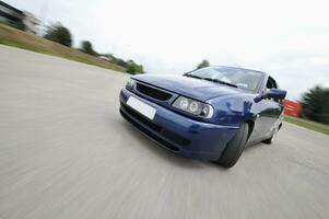 schnelles auto bewegt sich mit bewegungsunschärfe foto