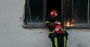 Feuerwehrmann Held Tragen Baby Mädchen aus von Verbrennung Gebäude Bereich von Feuer Vorfall. Rettung Menschen von gefährlich Platz foto