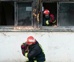 Feuerwehrmann Held Tragen Baby Mädchen aus von Verbrennung Gebäude Bereich von Feuer Vorfall. Rettung Menschen von gefährlich Platz foto