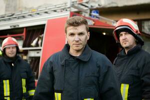 Gruppe von Feuer Kämpfer Stehen zuversichtlich nach ein Gut erledigt Rettung Betrieb. Feuerwehrmänner bereit zum Notfall Service. foto