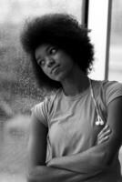 Porträt einer jungen afroamerikanischen Frau im Fitnessstudio, während sie Musik hört foto