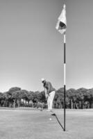 Golf Spieler Schlagen Schuss mit Verein auf Kurs foto