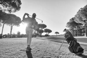 Golfspieler, der mit Schläger schlägt foto