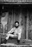 Porträt eines jungen Hipsters vor einem Holzhaus foto