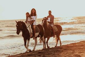 Die Familie verbringt Zeit mit ihren Kindern beim gemeinsamen Reiten an einem Sandstrand. selektiver Fokus foto