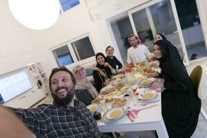 eid Mubarak Muslim Familie haben iftar Abendessen nehmen Bilder mit Handy, Mobiltelefon Telefon während Essen traditionell Essen während Ramadan schlemmen Monat beim heim. das islamisch halal Essen und Trinken islamisch famil foto