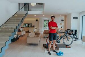 Foto von ein entschlossen Triathlet Stehen im ein modern groß Leben Zimmer, hinter ihm ist seine Ausbildung Fahrrad