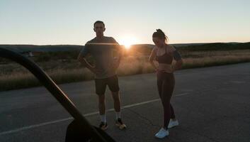 gesund jung Paar Joggen im das Stadt Straßen im das früh Morgen mit ein schön Sonnenaufgang im das Hintergrund. foto