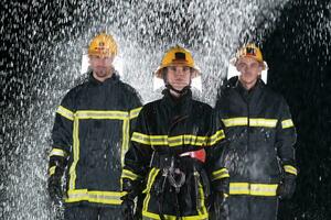 Porträt von ein Gruppe von Feuerwehrleute Stehen und Gehen mutig und optimistisch mit ein weiblich wie Mannschaft Führer. foto