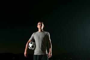 Porträt von ein jung gut aussehend Fußball Spieler Mann auf ein Straße spielen mit ein Fußball Ball. foto