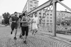 Gruppe junger Leute, die über die Brücke joggen foto